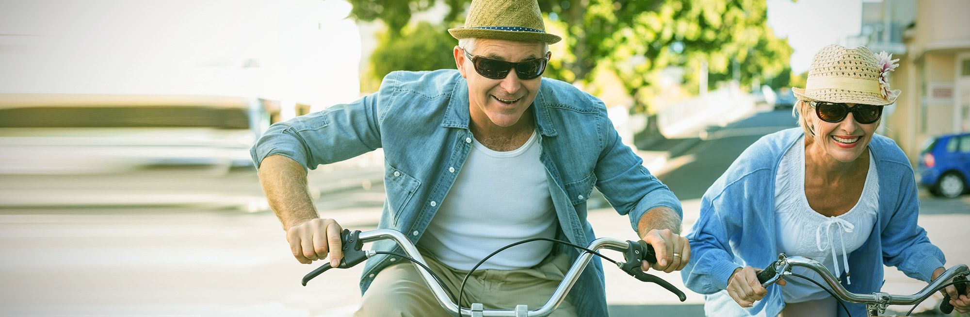 A retired couple riding bicycles and having fun.